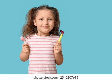 Cute little girl with lollipop and birthday party whistle on blue background - Powered by Shutterstock