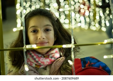 Cute Little Girl Looking Christmas Lights Looking At Camera With Illusion