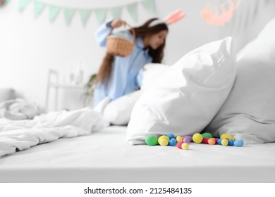 Cute little girl looking for Easter eggs in bedroom
