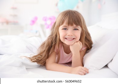 Cute Little Girl Lying In Bed At Home