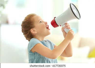 Cute little girl with megaphone at home