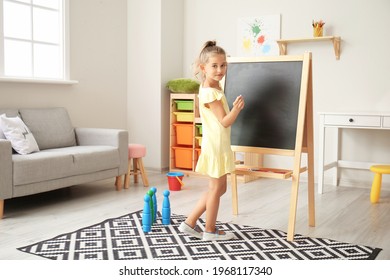 Cute Little Girl Near Blackboard In Kindergarten
