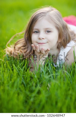 Similar – Littel girl sitting on grass looking curious