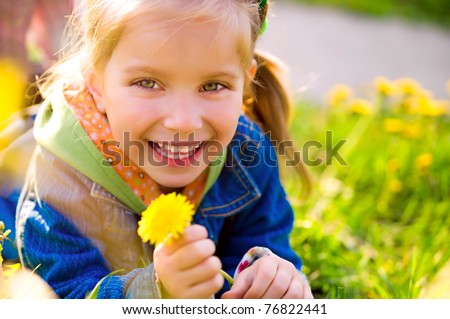 Cute little girl  on the meadow in spring day