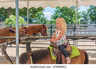 Cute Little Girl On A Pony Ride At The Fair