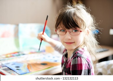 Cute little girl painting a picture in home studio - Powered by Shutterstock