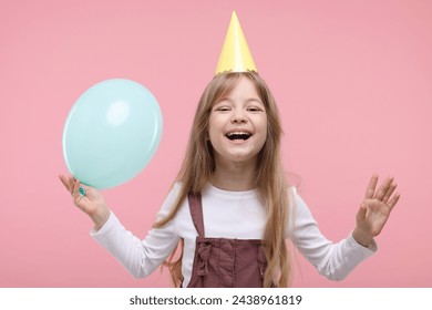 Cute little girl in party hat with balloon on pink background - Powered by Shutterstock