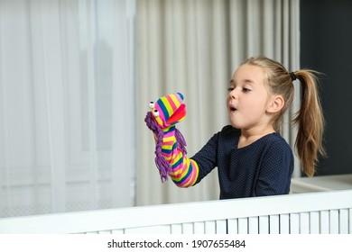 Cute Little Girl Performing Puppet Show At Home