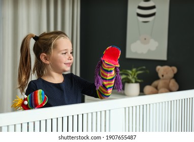 Cute Little Girl Performing Puppet Show At Home