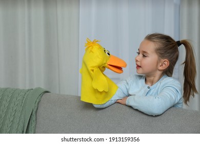 Cute Little Girl Performing Puppet Show At Home