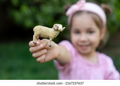 Cute little girl in pink dress with toy sheep. Portrait of happy child celebrate sacrificial feast (aka: Eid-al-Adha). Festival of sacrifices and kid. Preschooler outdoor. - Shutterstock ID 2167237637