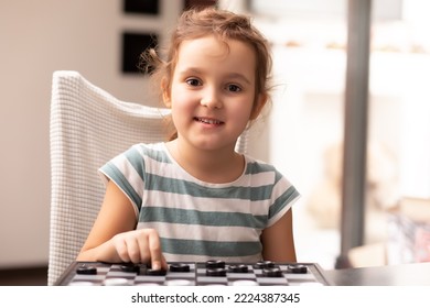 Cute Little Girl Play Checkers At Home