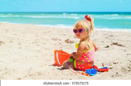 Cute Little Girl Play With Sand On Beach