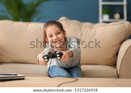 Similar – happy child playing video games with gamepad at home