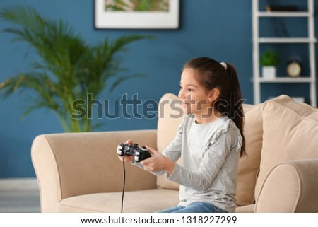 Similar – happy child playing video games with gamepad at home