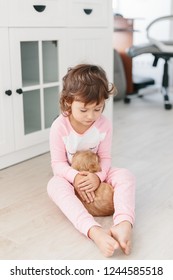 Cute little girl playing with dog english cocker spaniel puppy at home. Children and pets together