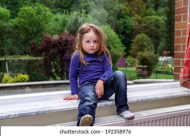 Cute Little Girl Playing With Drapes On The Window Marble  Sill