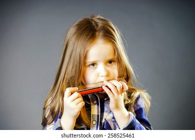 Cute Little Girl Playing Harmonica, Music Concept