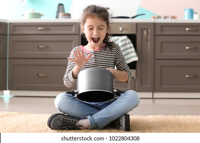 Cute Little Girl Playing With Saucepan As Drum Indoors