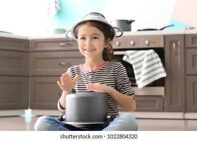 Cute Little Girl Playing With Saucepan As Drum Indoors