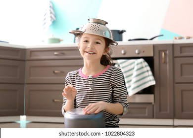 Cute Little Girl Playing With Saucepan As Drum Indoors