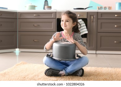 Cute Little Girl Playing With Saucepan As Drum Indoors