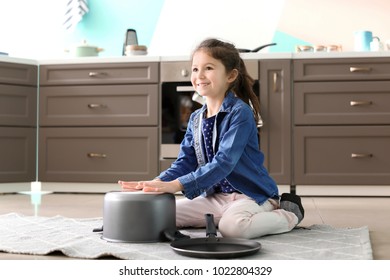 Cute Little Girl Playing With Saucepan As Drum Indoors