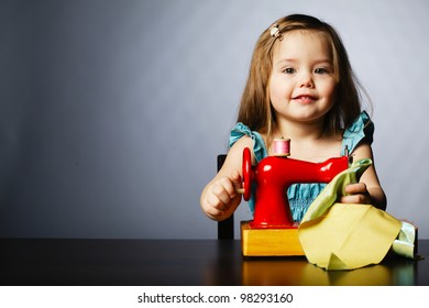 Cute Little Girl Is Playing With Sewing Machine