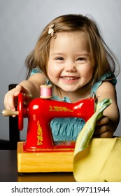 Cute Little Girl Is Playing With Sewing Machine