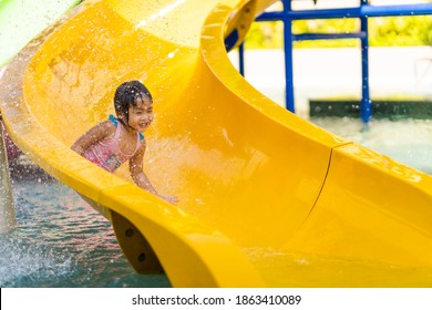 Cute Little Girl Playing Waterslide At Waterpark.