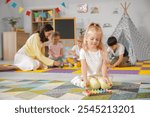 Cute little girl playing xylophone in kindergarten