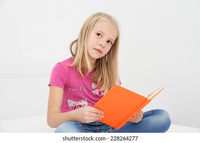 Cute little girl is reading book
