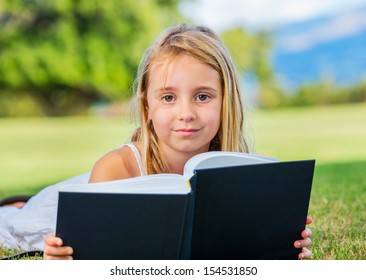 Cute Little Girl Reading Outside On Stock Photo 154531850 