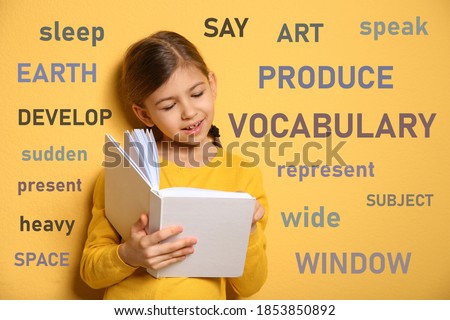 Cute little girl reading vocabulary surrounded by different words in English on yellow background