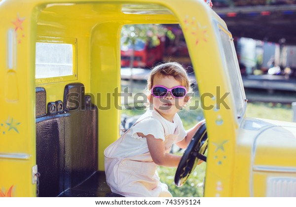 Cute little girl\
riding a car in luna park