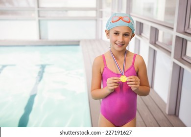 Cute little girl showing her swimming medal at the leisure center - Powered by Shutterstock