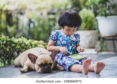 Cute Little Girl Sit With Dog Playing Calculator Outdoor.