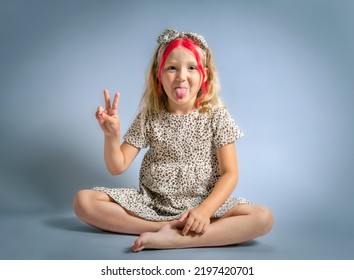 Cute Little Girl Sit On Floor. Caucasian Kid Studio Shot Portrait.