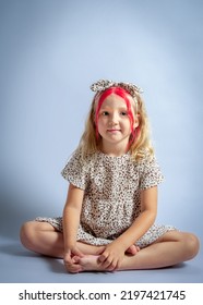 Cute Little Girl Sit On Floor. Caucasian Kid Studio Shot Portrait.