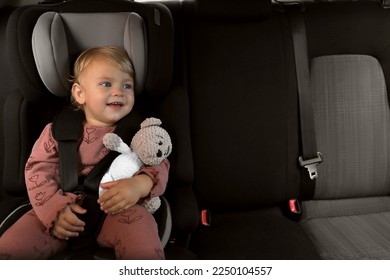 Cute little girl sitting in child safety seat inside car - Powered by Shutterstock