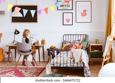 Cute Little Girl Sitting At Desk In Her Stylish Vintage Bedroom With Workspace