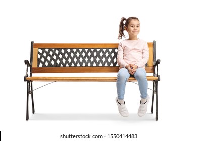 Cute little girl sitting on a bench and looking at the camera isolated on white background