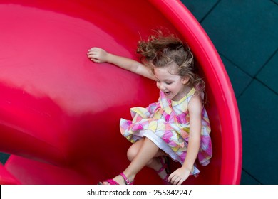 Cute little girl sliding on playground