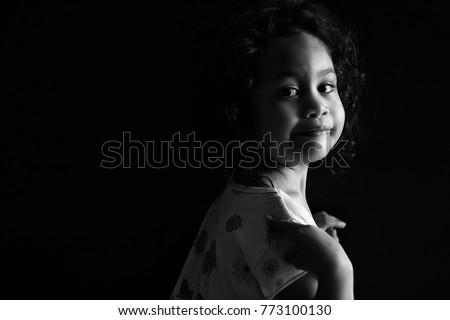 Cute little girl smiling in black and white format.