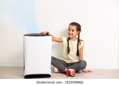 Cute Little Girl Standing Breathing At Air Purifier. Clean Air Concept