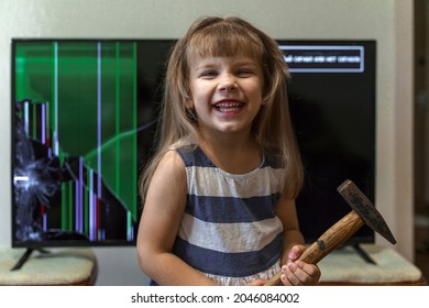 Cute Little Girl Standing In Front Of Tv With Broken Screen With Hammer