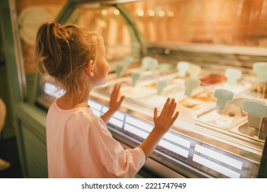 Cute little girl standing near ice-cream shop, choosing ice-cream. - Powered by Shutterstock