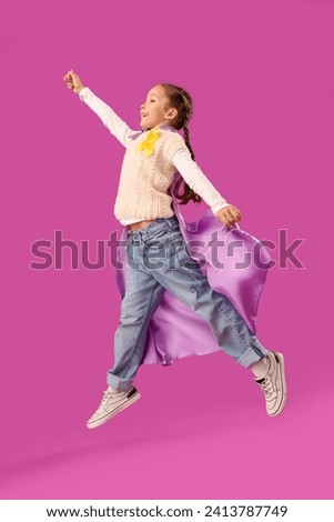 Cute little girl in superhero costume with yellow ribbon on purple background. Childhood cancer awareness concept