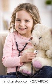 Cute little girl with teddy bear and stethoscope.