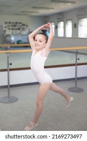 Cute Little Girl Toddler Ballerina In Pale Pink Tutu And Ballet Shoes Practicing Dance Jump.